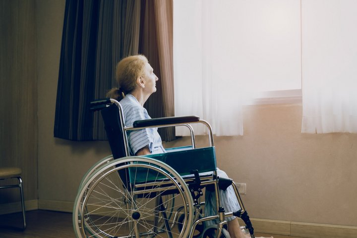 Retirement and Lonely women concept.Panoramic caucasian elderly woman in wheelchair while looking out the window in nursing home or hospital.